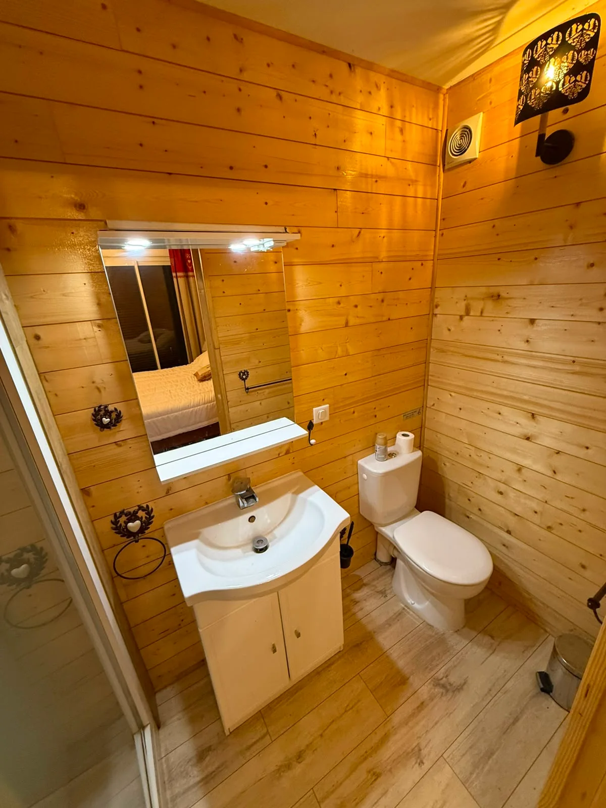 Salle d’eau privative en bois avec vasque et miroir éclairé