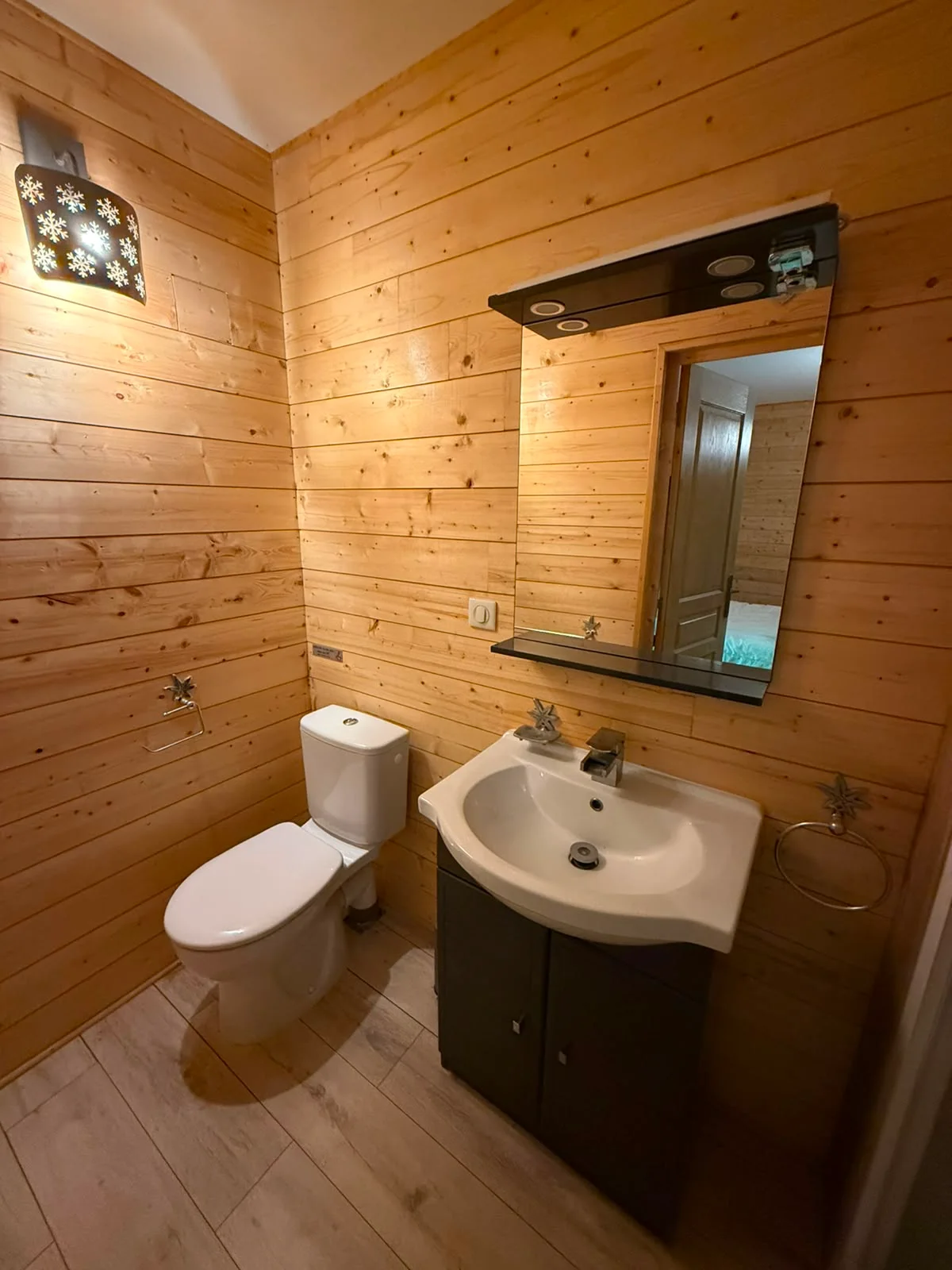 Private timber shower room with basin, mirror and toilet